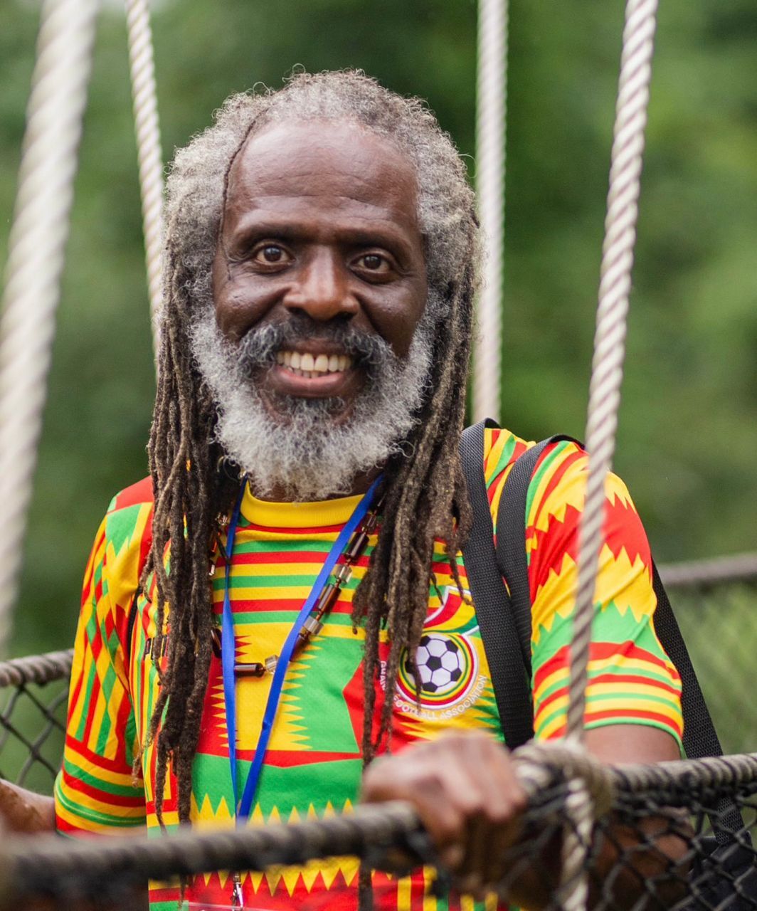 Brian Templeton wearing traditional African kente cloth, smiling warmly - author exploring cultural identity and human experience